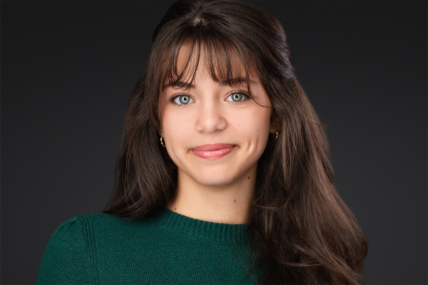 A captivating actor headshot of a woman in a green top, demonstrating the range and coaching provided in a full individual session in Lakeland by James Connell.