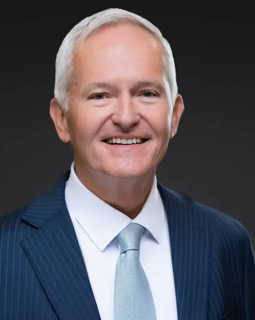 Corporate headshot of a man in a pinstripe suit on a dark backdrop, Tampa