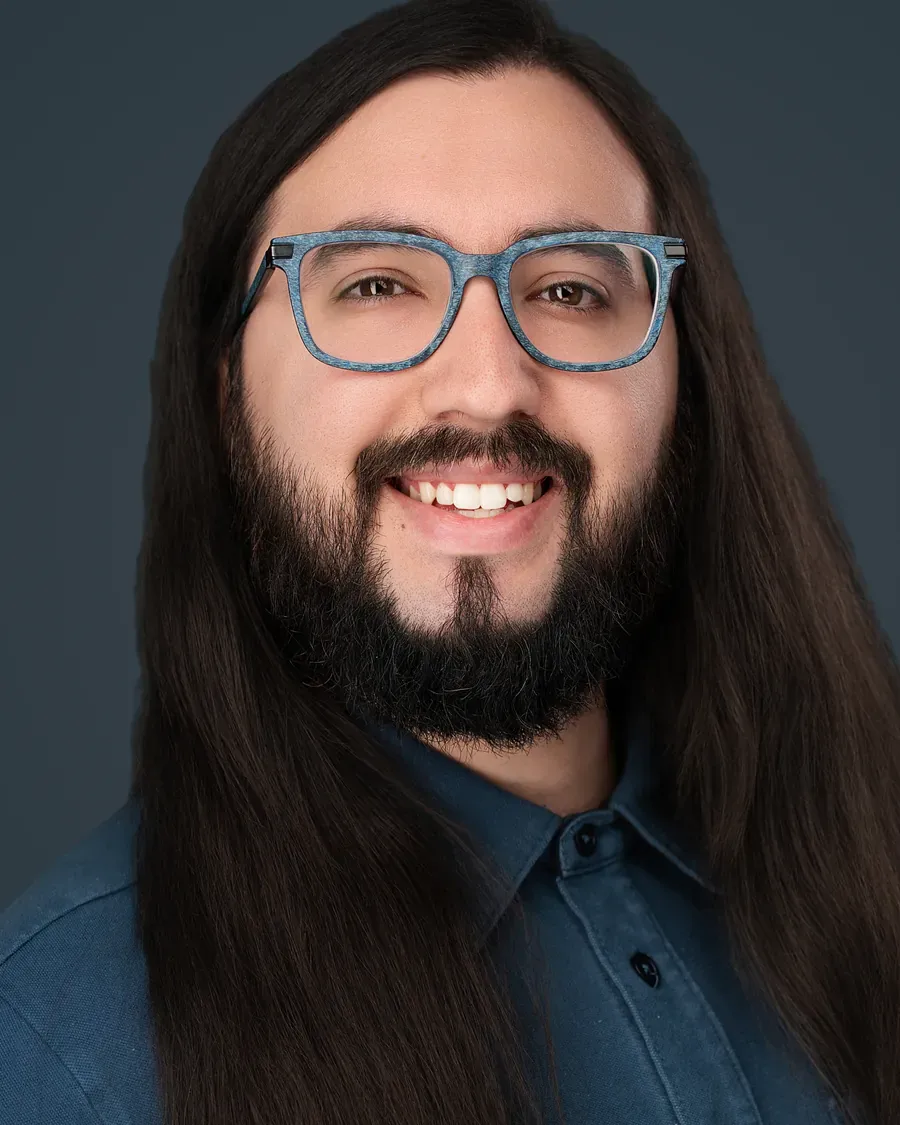 Creative professional with long dark hair on a teal backdrop, Tampa headshot