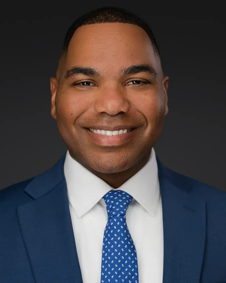 Tampa executive headshot of a man in a navy suit on a dark backdrop