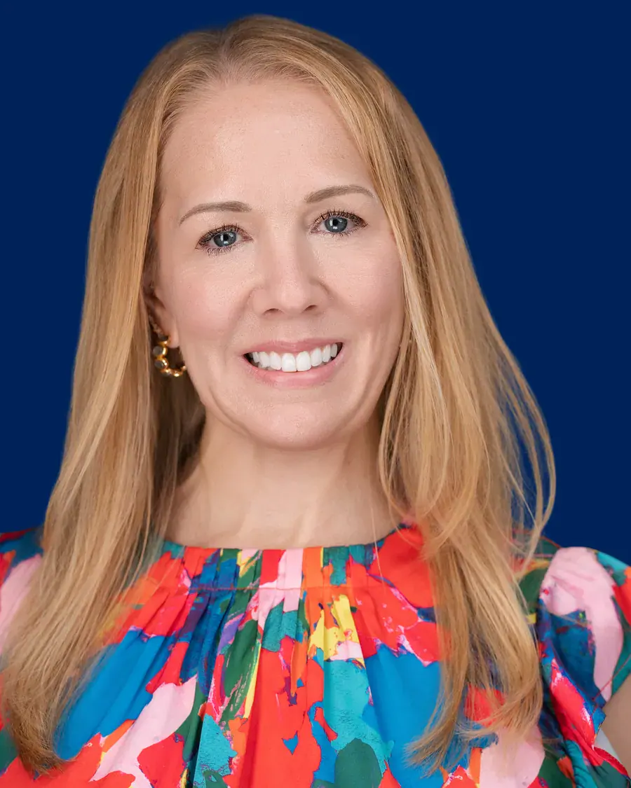 Woman in a colorful top on a royal blue backdrop, Tampa headshot