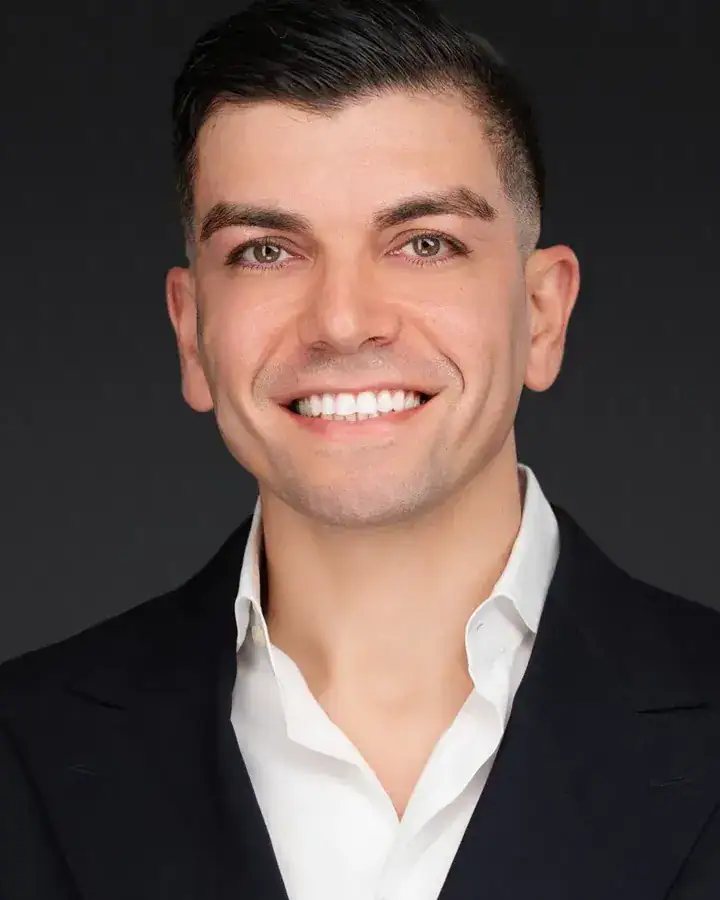 Smiling Tampa professional in a dark suit and white open-collar shirt, studio headshot